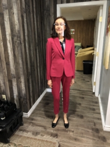 Maura in a fuchsia pant suit with a face shield on set for Foreclosure film. 